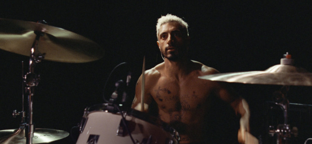 Kadr z filmu "Sound of Metal". Mężczyzna za zestawem perkusyjnym.