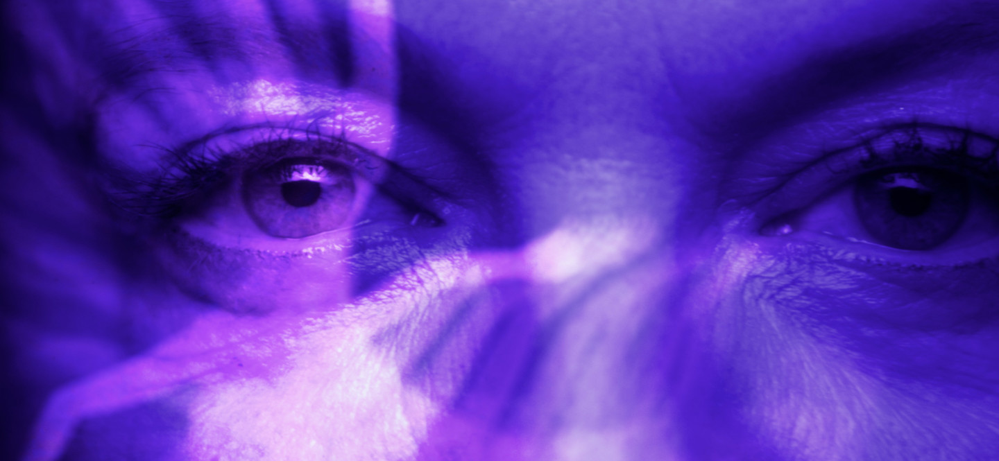 Na zdjęciu oczy kobiety podświetlone na fioletowo.
