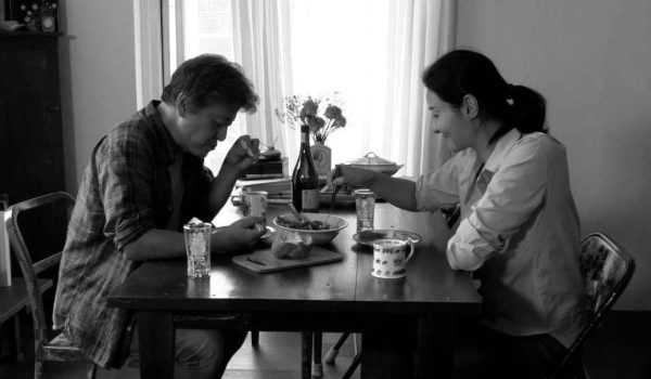 Na zdjęciu kobieta i mężczyzna jędzą przy stole.