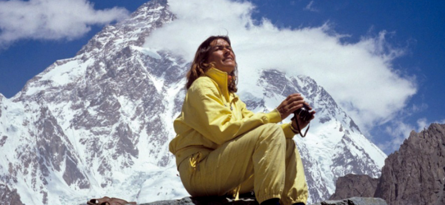Na zdjęciu kobieta siedząca na szczycie góry.