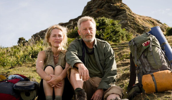 Kobieta i mężczyzna siedzący na zboczu góry.