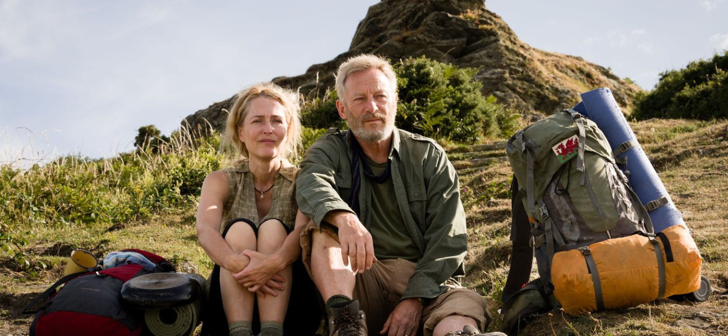 Kobieta i mężczyzna siedzący na zboczu góry.