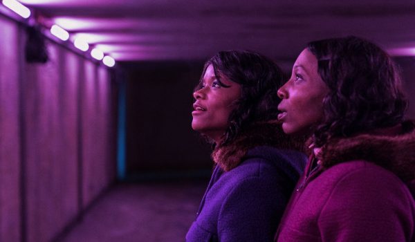 Na zdjęciu dwie dziewczyny, bliźniaczki, stoją w przejściu podziemnym.