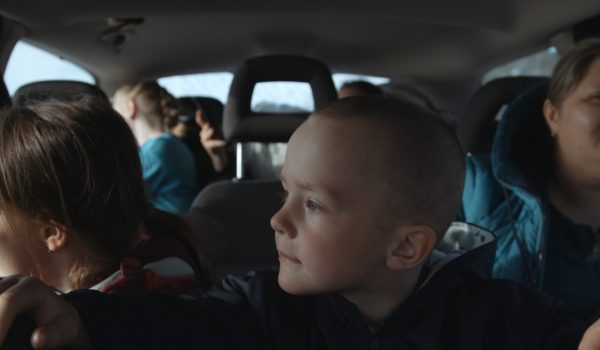 Na zdjęciu rodzina siedząca w samochodzie.
