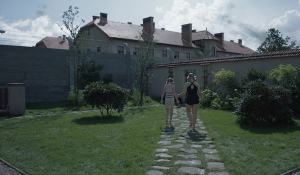 Na zdjęciu dwie dziewczyny idące ścieżką w ogrodzie