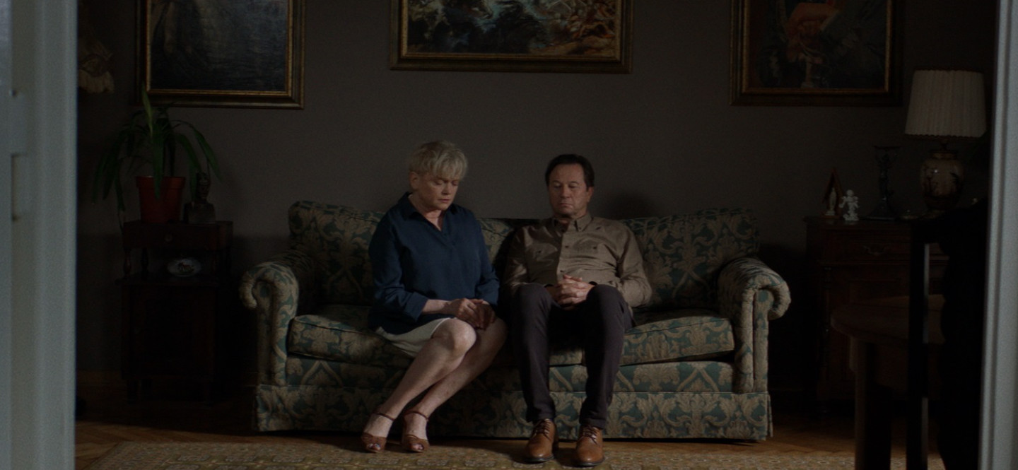 Na zdjęciu kobieta i mężczyzna siedzący na kanapie w pokoju.
